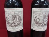 two bottles of wine sitting on top of a table next to each other