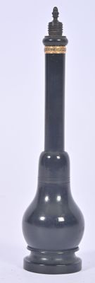 a black vase with a gold top sitting on a white surface