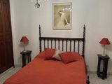 a bedroom with a bed and a chandelier hanging from the ceiling