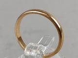 a gold ring sitting on top of a clear glass holder
