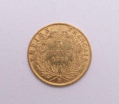 gros plan d'une pièce d'or sur une surface blanche