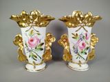 deux vases décorés de fleurs, posés sur une table