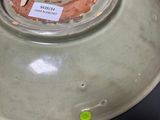 a green bowl with a hole in it on a table