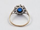 a close up of a ring with a blue stone in it