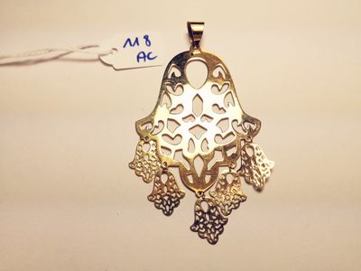 an image of a gold pendant with filigree filigrees on it