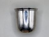 a silver cup that is sitting on a white surface