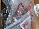 many pairs of glasses in a box on the floor