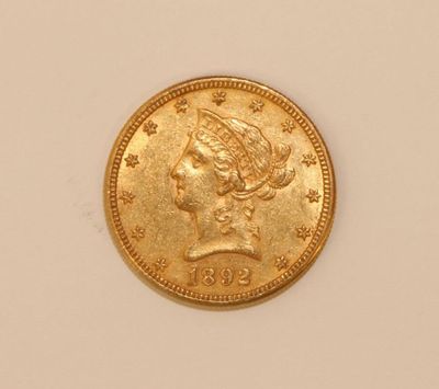 a close up of a gold coin on a white surface