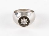 un gros plan d'une bague en argent sertie d'un diamant au centre