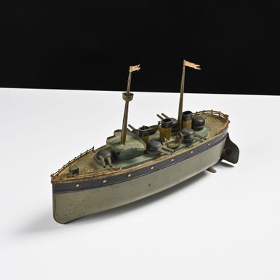 une petite maquette de bateau posée sur une surface blanche
