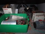 a green container filled with assorted electronics on a table