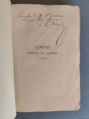 un livre ouvert posé sur une table à côté d'une tasse de café