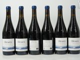 six bouteilles de vin sont alignées sur une table