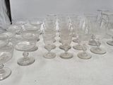 beaucoup de verres posés sur une table recouverte d'une nappe blanche