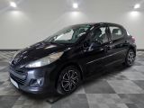 a black car is parked in a room with a checkered floor