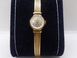 a close up of a watch on a velvet case on a white surface