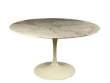 une table en marbre blanc avec un piètement rond et un socle blanc