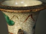 a close up of a vase with a bird on it