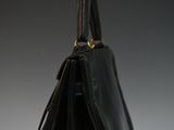a close up of a black handbag hanging on a wall
