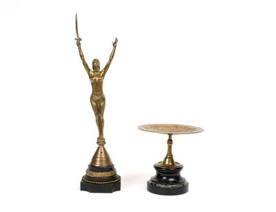 a statue of a woman holding a sword next to a small table