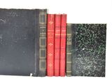 trois livres sont alignés sur une surface blanche