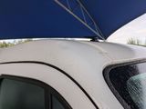 a white car with a blue umbrella on top of it
