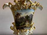 a vase with a painting on it sitting on a table