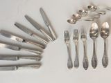 un grand nombre de cuillères et de fourchettes en argent disposées sur une table