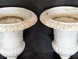 two white vases that are sitting on a table