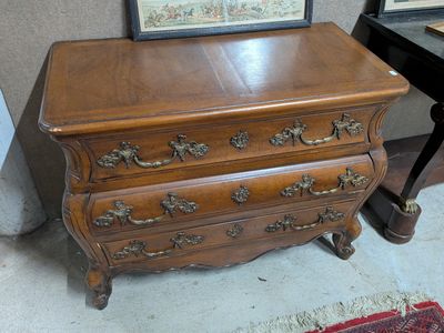 une commode en bois surmontée d'un tableau