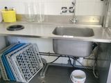 a sink in a small kitchen with a lot of dishes on the counter