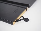 a close up of a black book with a key on it
