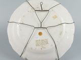 underside view of a white plate with wire wrapped around it