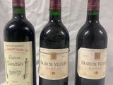trois bouteilles de vin sont alignées sur une table