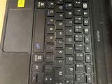 a black laptop with a yellow sticker on the keyboard