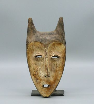 une image d'un masque en bois sur un support