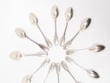 plusieurs cuillères et cuillères à soupe disposées en cercle sur une surface blanche