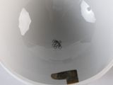 a white bowl with a brown handle sitting on a table