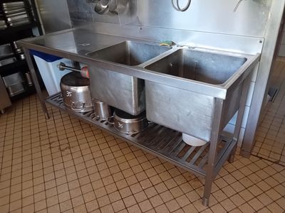 two sinks in the kitchen with pots and pans on the counter
