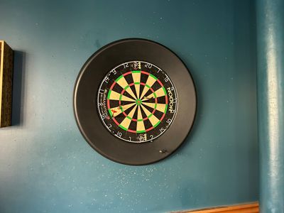 une cible de fléchettes fixée au mur d'une pièce