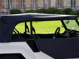 a white jeep with a black top parked in front of a building