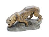 statue en bronze d'un chien sur un rocher sur fond blanc