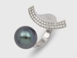 une bague en perle noire et diamants sur fond blanc
