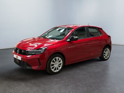 Une voiture rouge est garée dans une pièce aux murs blancs.