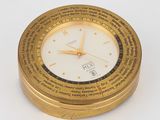 une horloge dorée avec un cadran blanc posée sur un fond blanc
