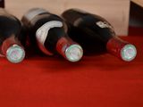 several bottles of wine are lined up on a red table