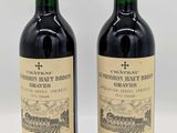 deux bouteilles de vin rouge posées l'une à côté de l'autre sur une table