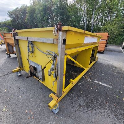 a yellow dumpster sitting in the middle of a parking lot