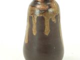 a brown vase that is sitting on a white surface