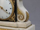 une horloge blanche et or posée sur une table